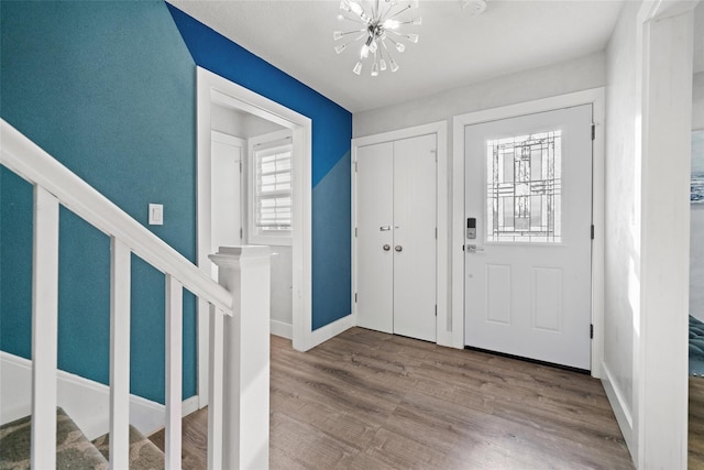 foyer entrance featuring wood-type flooring and a notable chandelier