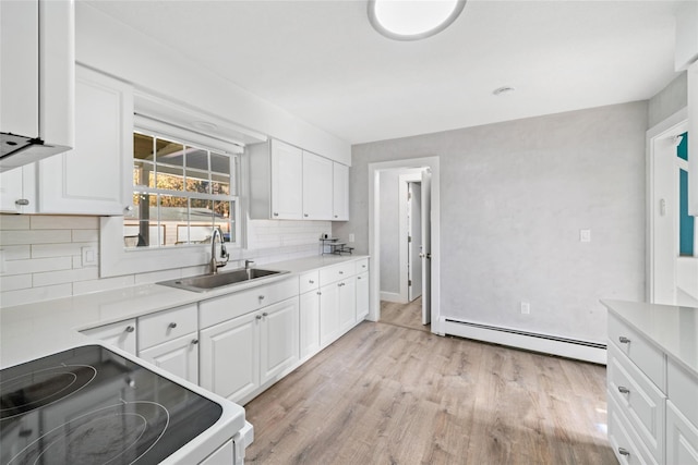 kitchen with stove, white cabinets, sink, light hardwood / wood-style flooring, and a baseboard radiator