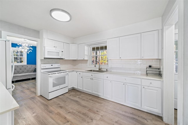 kitchen featuring white cabinets, light wood-type flooring, white appliances, and sink