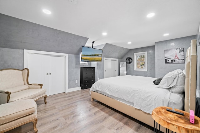 bedroom with a closet, vaulted ceiling, and light wood-type flooring