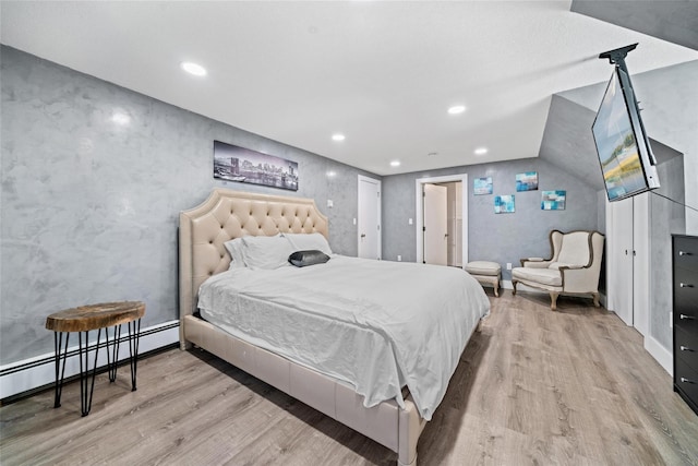 bedroom with light wood-type flooring and a baseboard radiator