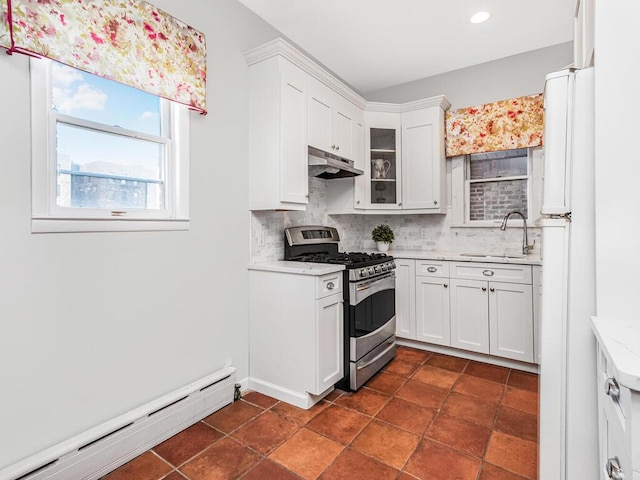 kitchen with gas stove, sink, baseboard heating, white fridge, and white cabinets