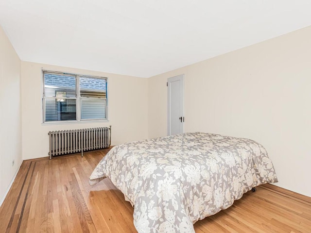 bedroom with hardwood / wood-style floors and radiator