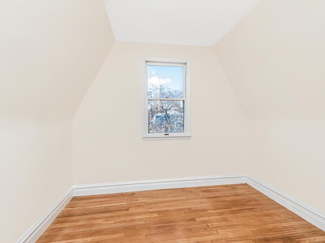 bonus room with light wood-type flooring and lofted ceiling