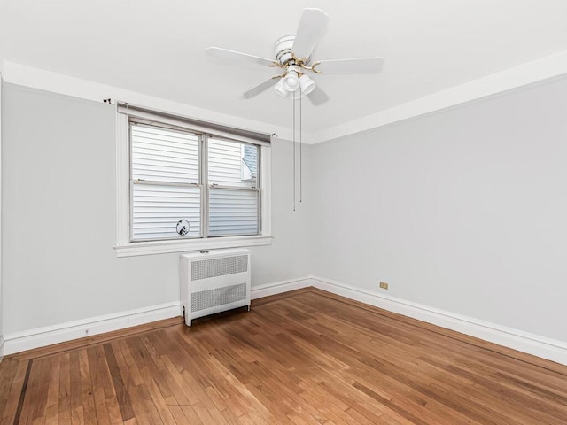 unfurnished room featuring radiator, ceiling fan, and hardwood / wood-style flooring