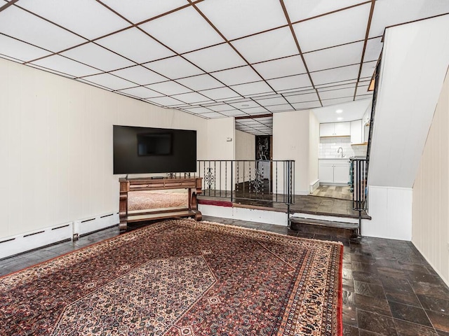 unfurnished living room with a drop ceiling and sink