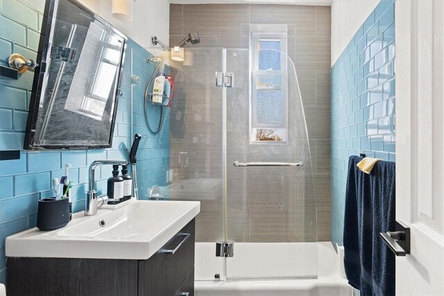 bathroom featuring vanity, tasteful backsplash, and tile walls