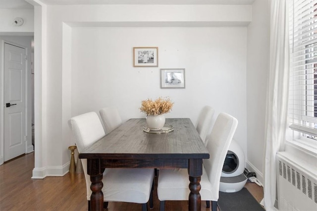 dining space with radiator and dark hardwood / wood-style flooring