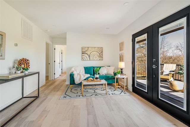 living area with french doors and light wood-type flooring