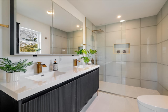 bathroom with toilet, vanity, tile walls, and tiled shower