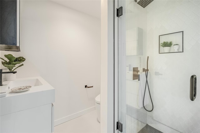 bathroom featuring vanity, toilet, and a shower with door