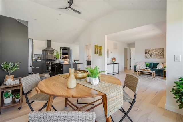 dining area featuring ceiling fan, light hardwood / wood-style floors, and vaulted ceiling