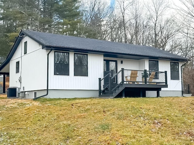 rear view of property featuring central AC, a wooden deck, and a lawn