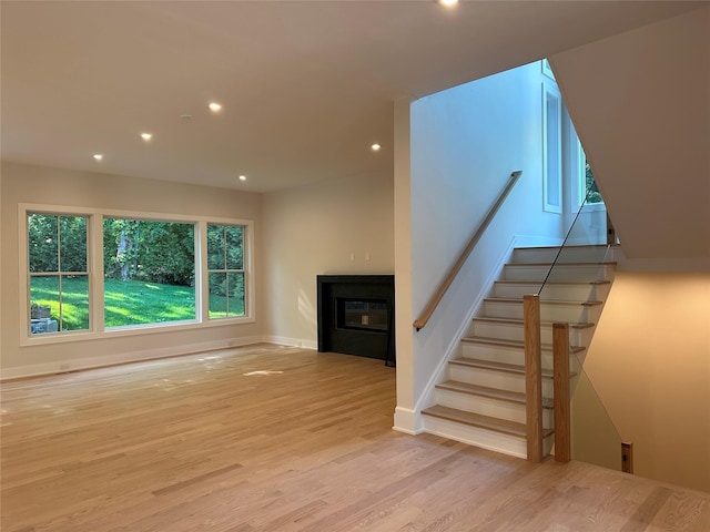 239 Rock Creek Ln, Scarsdale, NY 10583 - unfurnished living room featuring recessed lighting, a glass covered fireplace, wood finished floors, stairway, and baseboards