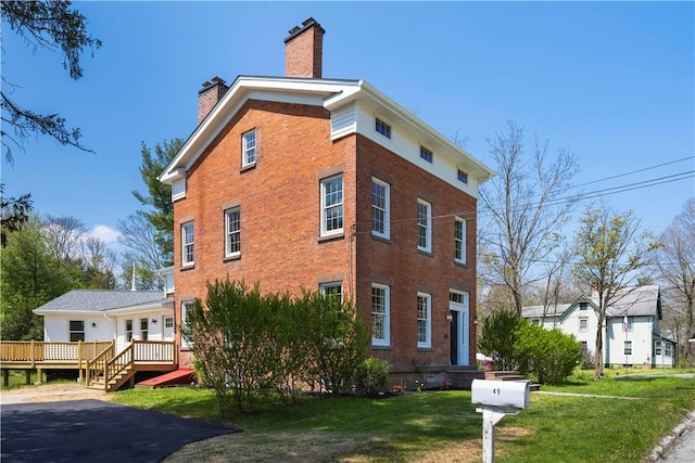 view of property exterior featuring a lawn and a wooden deck