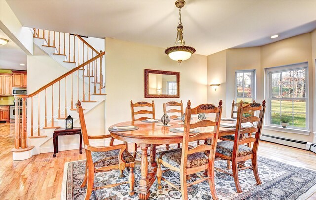 dining area with light wood-type flooring and a baseboard heating unit