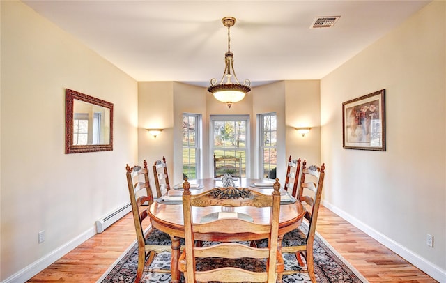 dining space featuring light hardwood / wood-style floors and a baseboard heating unit