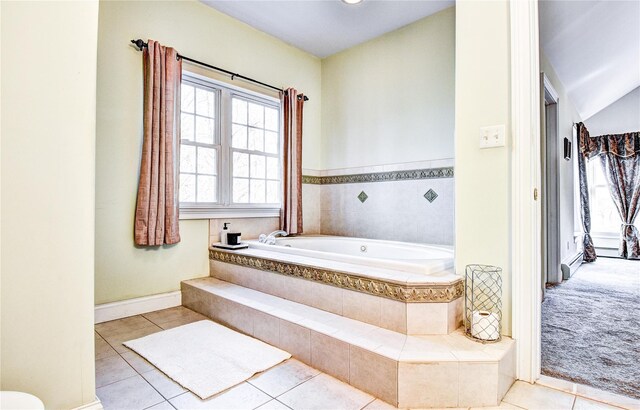 bathroom featuring tiled tub and tile patterned flooring