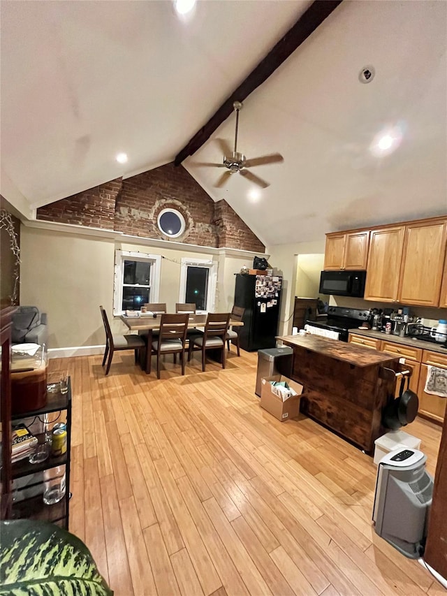 kitchen featuring ceiling fan, lofted ceiling with beams, brick wall, light hardwood / wood-style floors, and black appliances