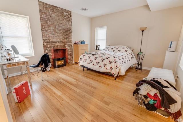 bedroom featuring a fireplace and hardwood / wood-style floors