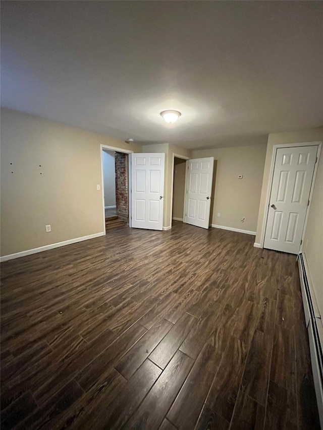 unfurnished bedroom with a baseboard radiator and dark wood-type flooring