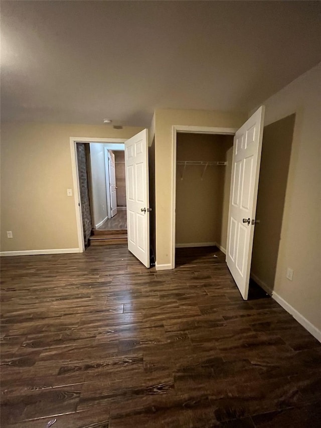 unfurnished bedroom with a closet and dark wood-type flooring