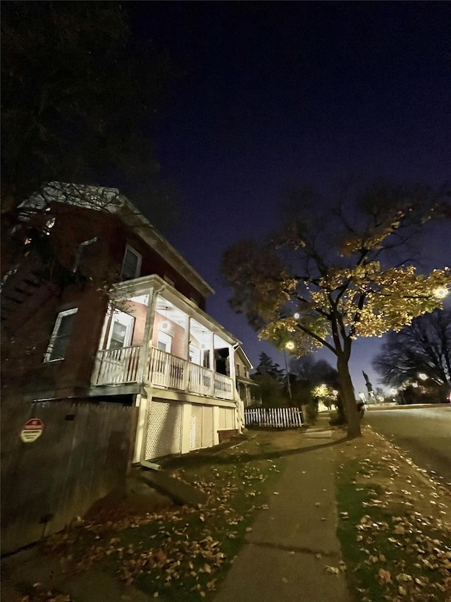 property exterior at night with covered porch