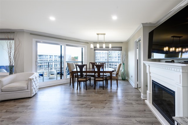 dining space featuring hardwood / wood-style floors, crown molding, and a chandelier