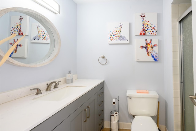 bathroom with vanity, toilet, and a shower with door