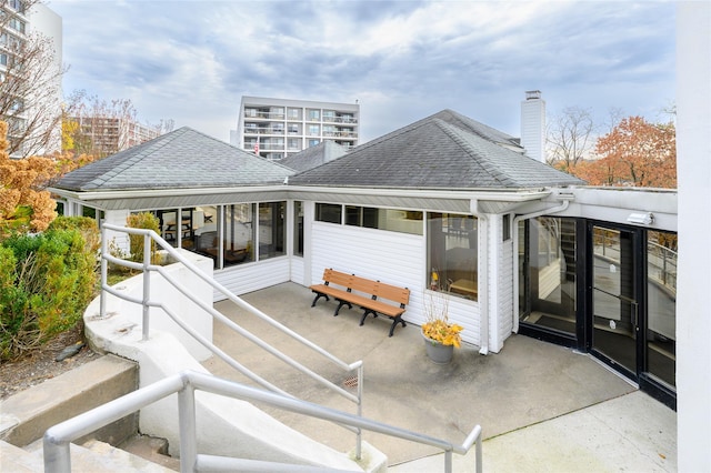 rear view of property featuring a sunroom