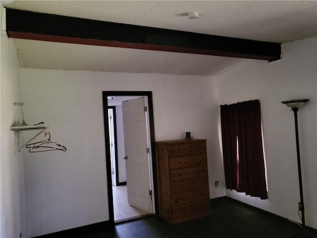 unfurnished bedroom with beam ceiling