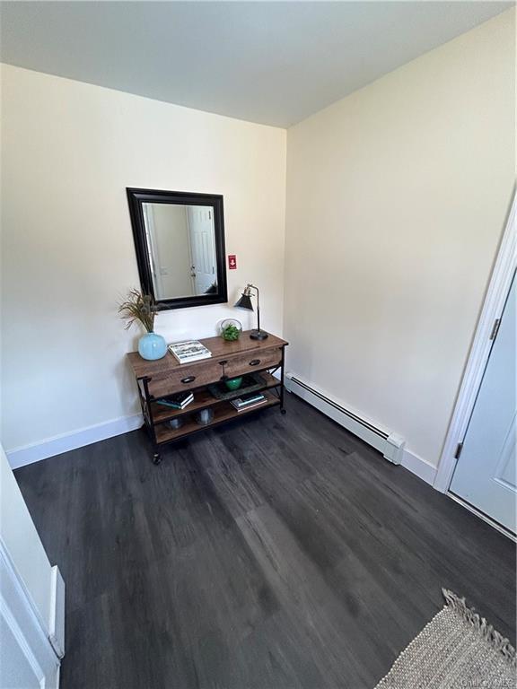 7065 Rte 209, Kerhonkson, NY 12446 - corridor with a baseboard heating unit, dark wood-style flooring, and baseboards