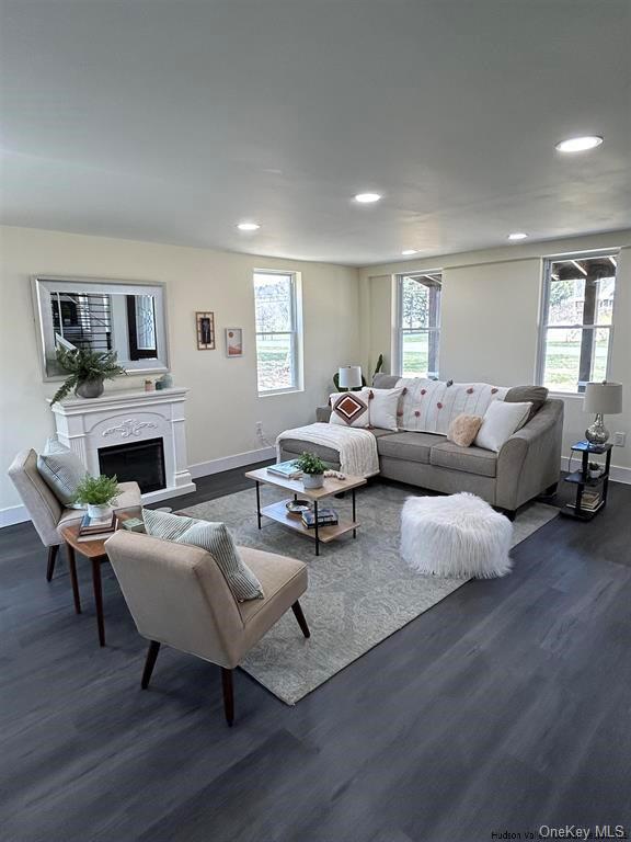 living room with a healthy amount of sunlight and dark wood-type flooring