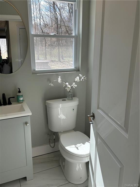 7065 Rte 209, Kerhonkson, NY 12446 - half bathroom with vanity, toilet, and baseboards