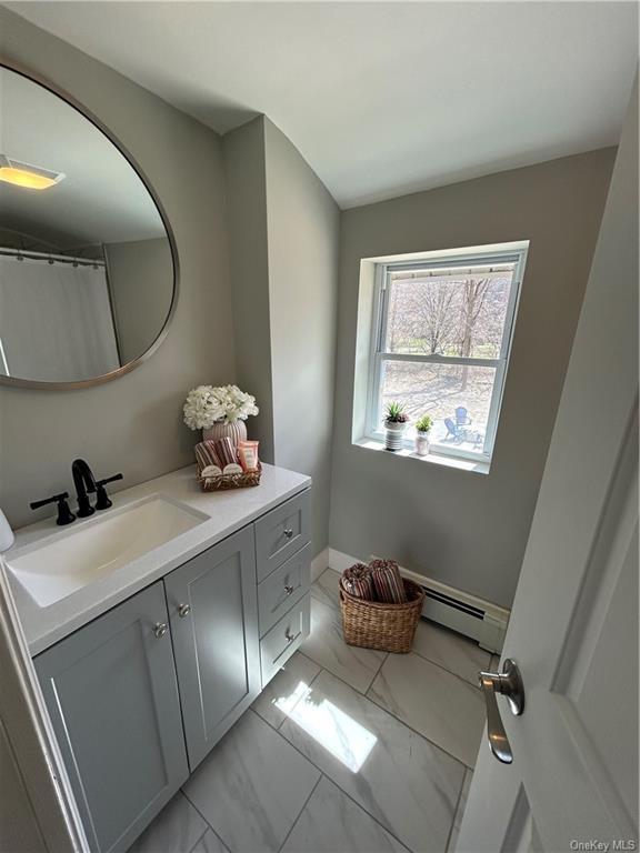 7065 Rte 209, Kerhonkson, NY 12446 - bathroom with baseboard heating, vanity, marble look tile flooring, and baseboards