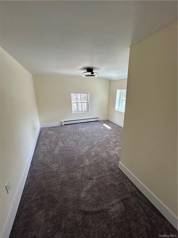 carpeted empty room with ceiling fan and a baseboard heating unit