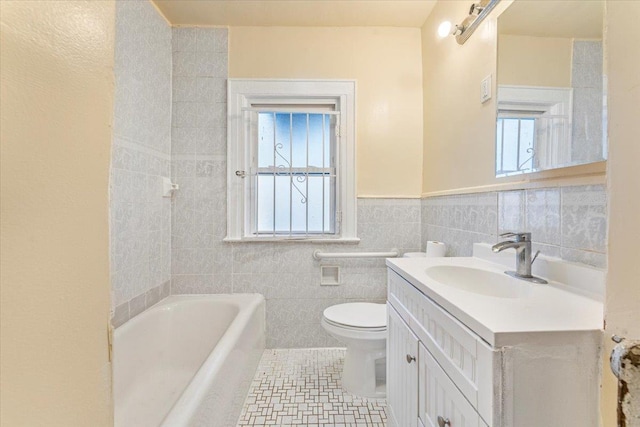 bathroom featuring a bathing tub, tile patterned floors, toilet, vanity, and tile walls