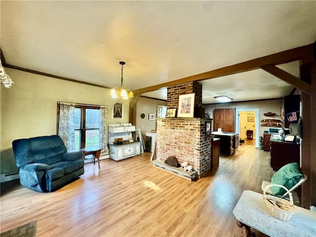 living room featuring ornamental molding, a baseboard heating unit, a notable chandelier, a fireplace, and light hardwood / wood-style floors