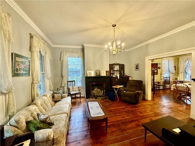 living room with wood-type flooring, an inviting chandelier, and ornamental molding