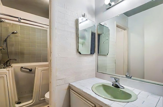 bathroom featuring tiled shower and vanity