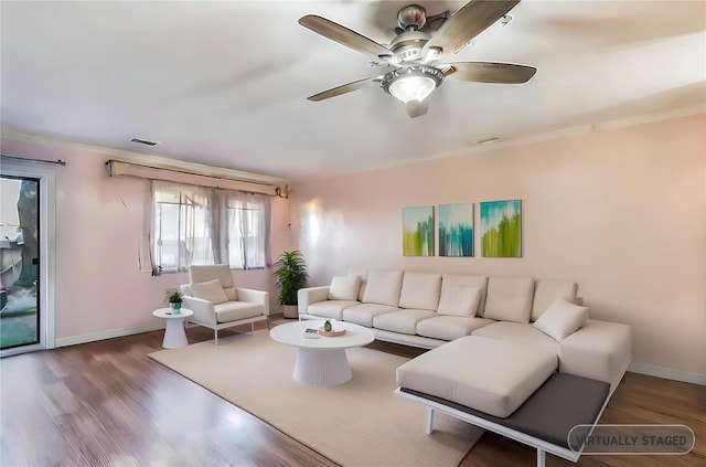 living room featuring hardwood / wood-style floors, ceiling fan, and ornamental molding