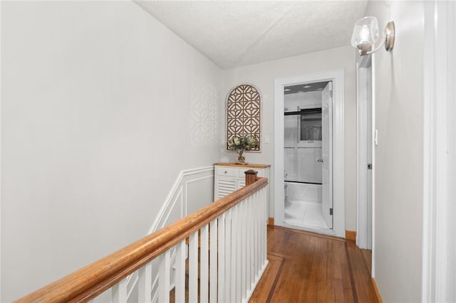 hallway with wood-type flooring and a textured ceiling