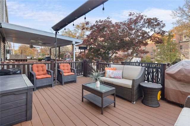 wooden deck featuring a grill, ceiling fan, and an outdoor hangout area