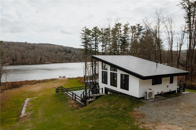 view of side of property featuring a lawn and a water view