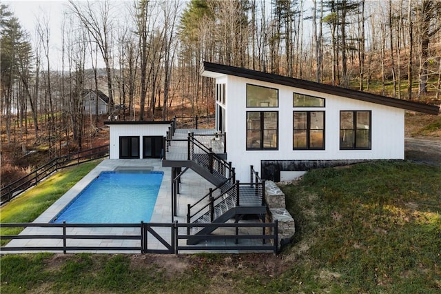 view of swimming pool with a lawn and a wooden deck