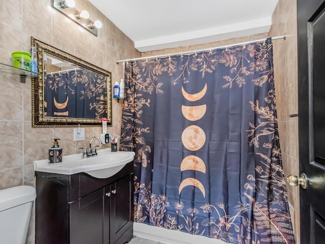 bathroom featuring a shower with shower curtain, vanity, toilet, and tile walls