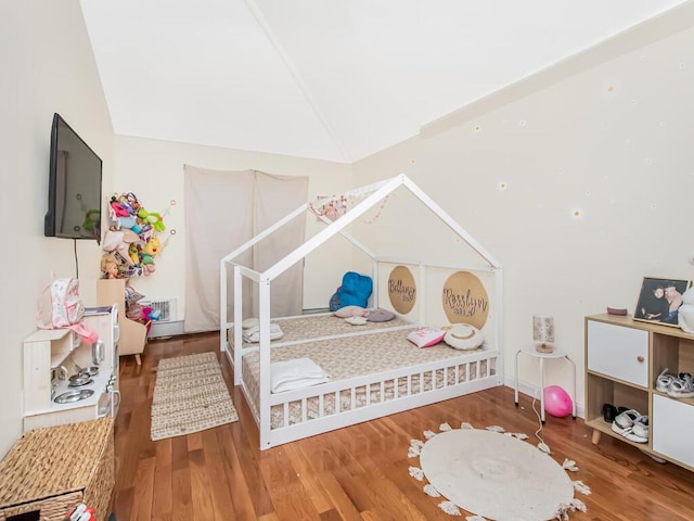 bedroom featuring hardwood / wood-style floors and lofted ceiling