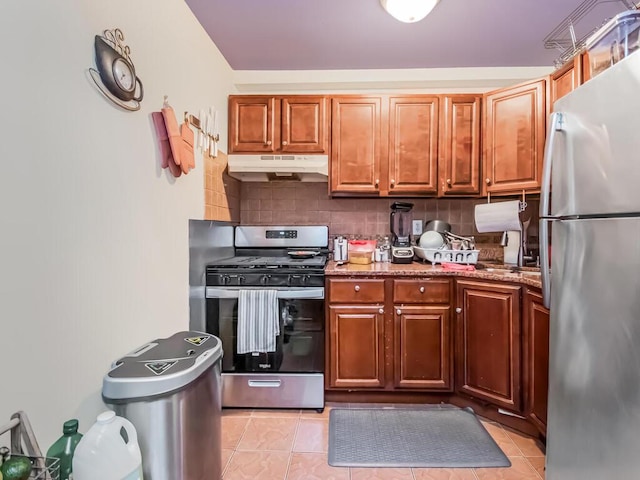 kitchen with light stone countertops, light tile patterned floors, backsplash, and stainless steel appliances