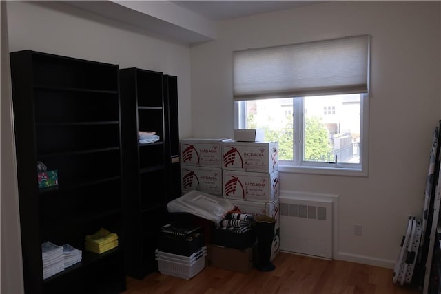 misc room featuring hardwood / wood-style floors and radiator heating unit