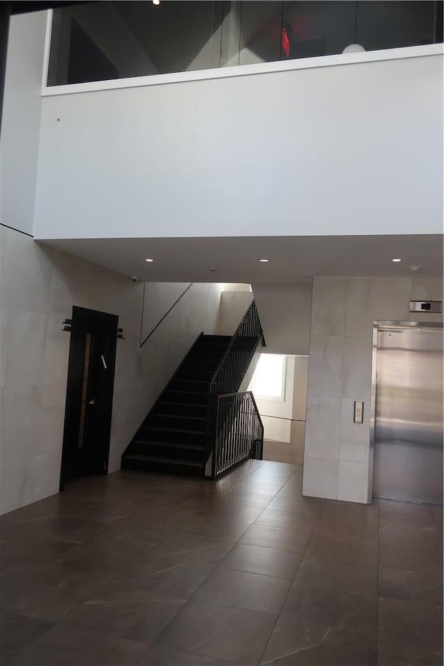 corridor featuring tile patterned flooring and tile walls